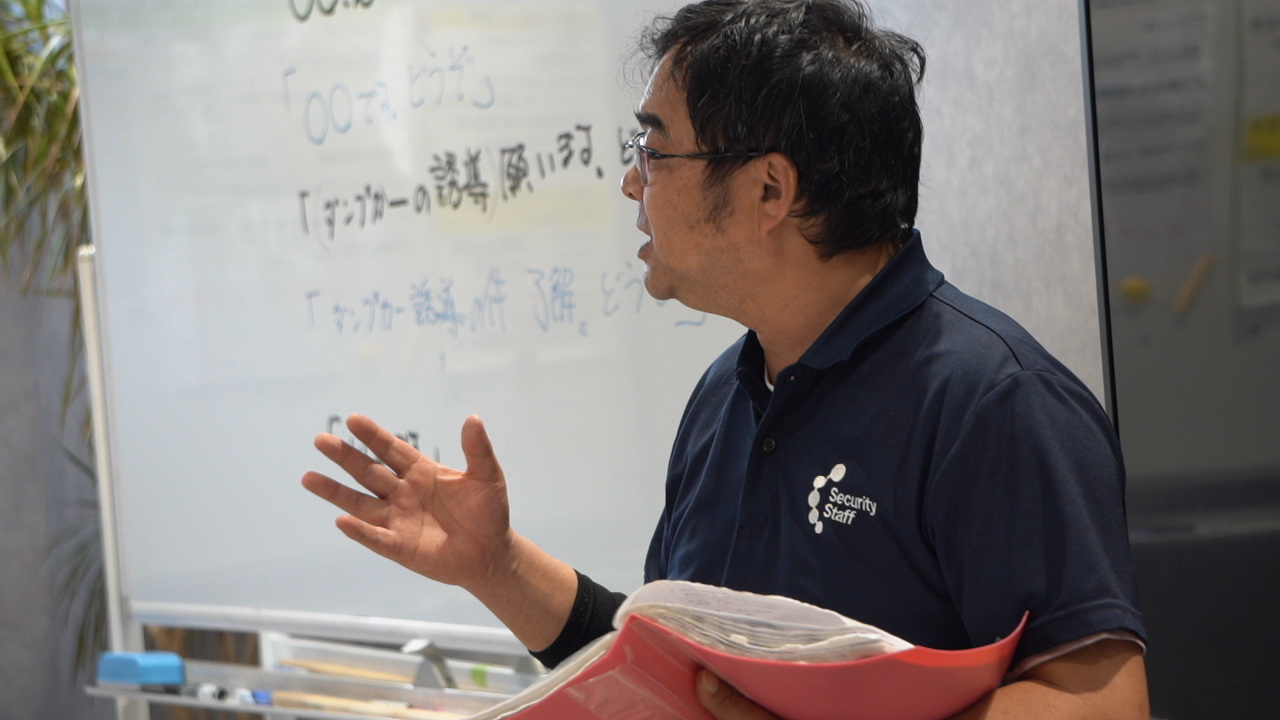 教材を使って資格取得の指導をする社員